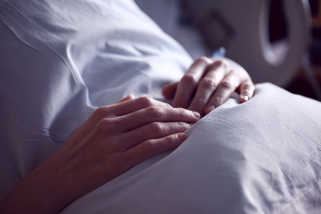 hands of patient in hospital bed
