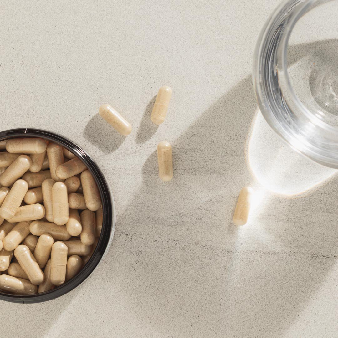 maca capsules and a glass of water