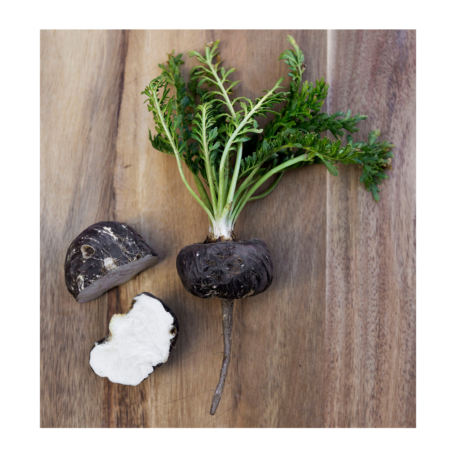 raw organic black maca roots cut open on a board