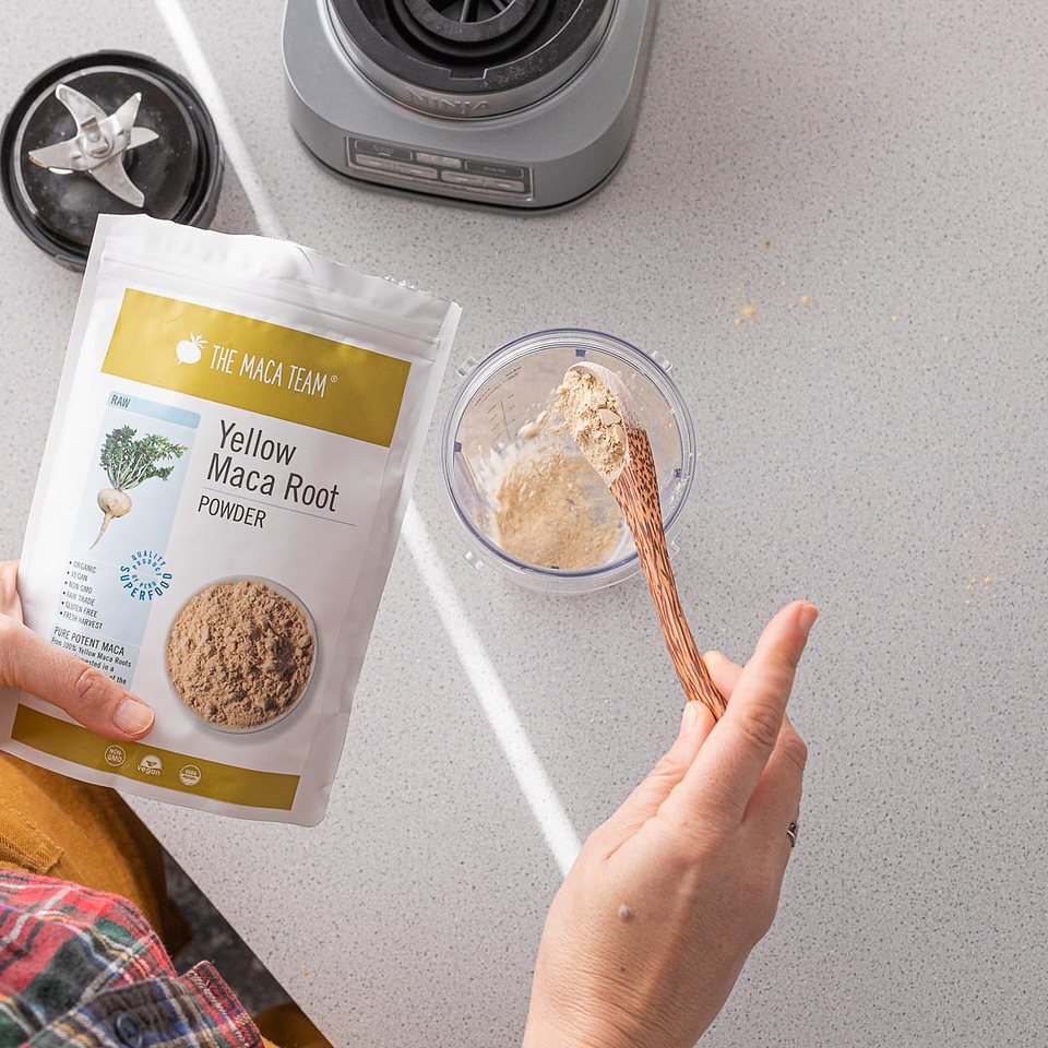 Organic raw yellow maca powder being added to a blender