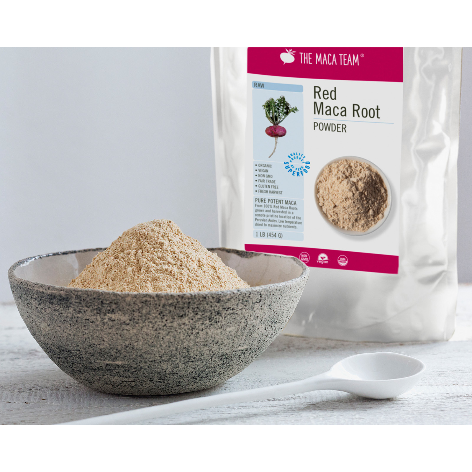Organic raw red maca powder in a bowl with product bag