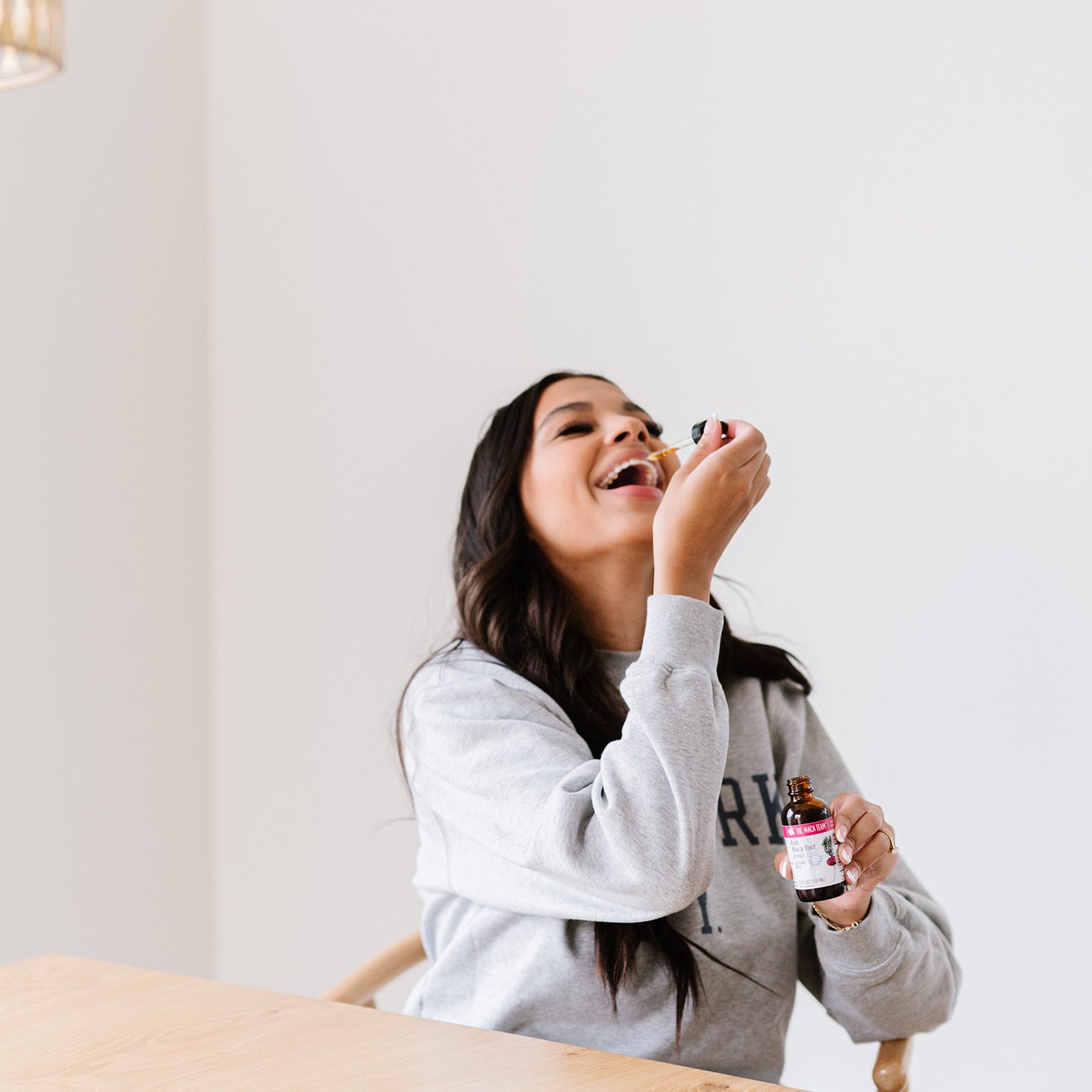 Woman taking Red Maca Extract under the tongue